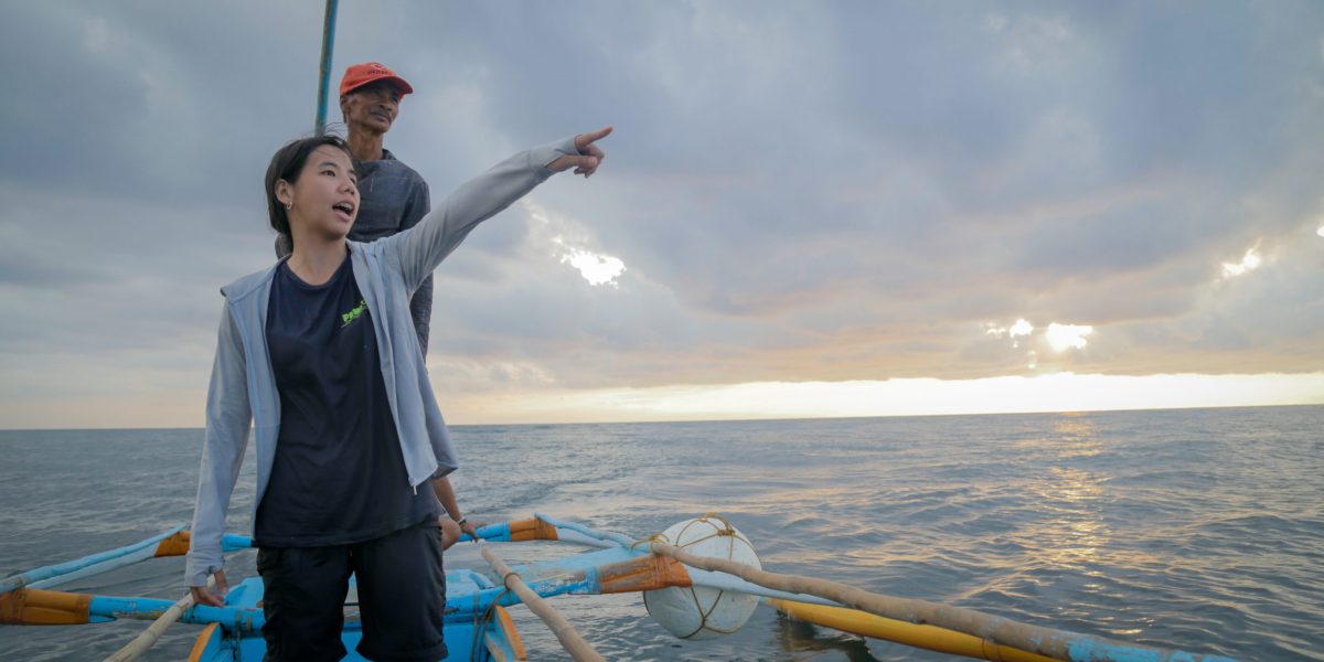 Erina Molina with a local fisherman points out to the fishing area. Photo by Glenn Barit